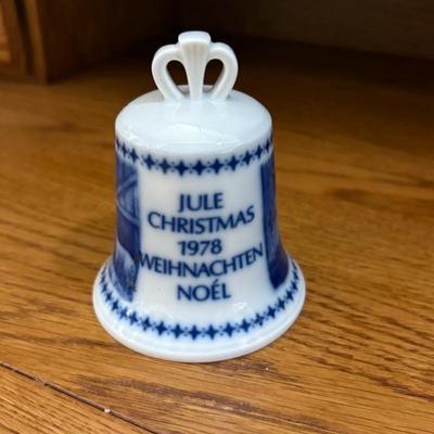 Sale Photo Thumbnail #90: AI assisted description:

This is a vintage Berlin Design Christmas bell from 1978, featuring the word "Christmas" in multiple languages. Here are some key details:
Design:
The bell is white with blue decorative patterns and text. The text includes "JULE,