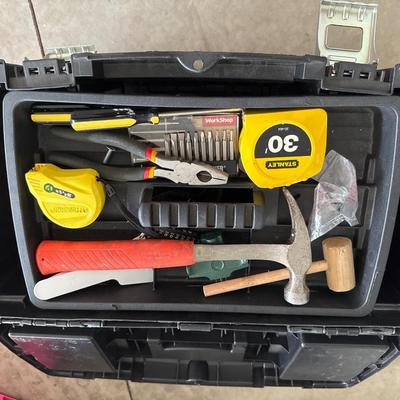 Black plastic toolbox with tools in it