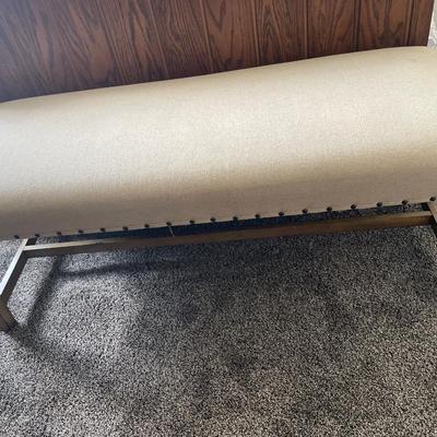 Fabric covered bench with pink blanket and pillow