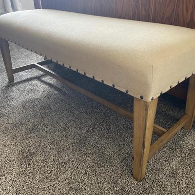 Fabric covered bench with pink blanket and pillow