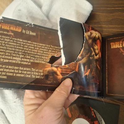 Sale Photo Thumbnail #275: The Mortal Kombat book has been chewed on (presumed by a dog) and the front cover and first few pages are damaged. The discs look good but since this is a PC game we arent sure if you need codes to install them- there are some codes on a few pieces of pap