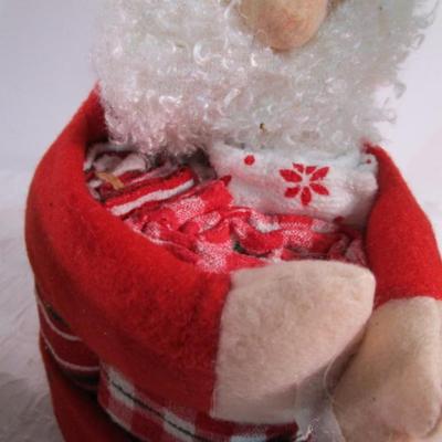 Christmas decorations and Santa holds 3 hand towels