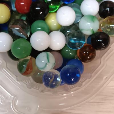BOWL FULL OF MARBLES AND LEATHER STRAP ROLLER SKATES