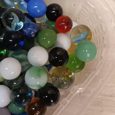 BOWL FULL OF MARBLES AND LEATHER STRAP ROLLER SKATES