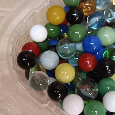 BOWL FULL OF MARBLES AND LEATHER STRAP ROLLER SKATES