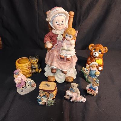 LARRGE GRANDMA IN A ROCKER AND VARIOUS FIGURINES SURROUNDING HER