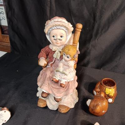 LARRGE GRANDMA IN A ROCKER AND VARIOUS FIGURINES SURROUNDING HER