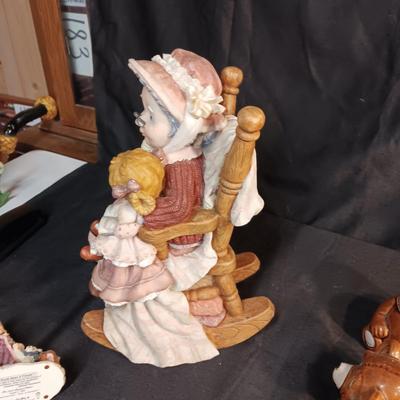 LARRGE GRANDMA IN A ROCKER AND VARIOUS FIGURINES SURROUNDING HER