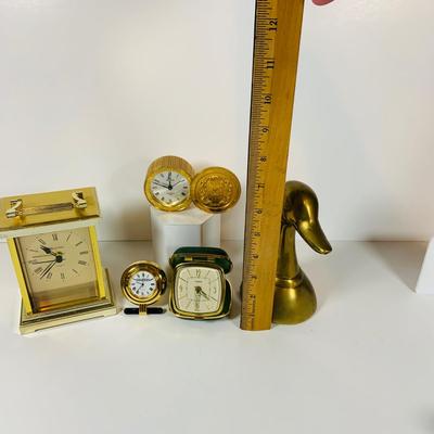 LOT 299: Clocks and Quacks - Brass Duck Book End, Bulova Quartz Mantle Clock, Florin Travel Clock, Swiza Swiss Coin Shaped Alarm Clock...