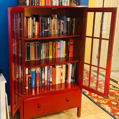 LOT 330: Red Wooden Book Case with Drawer and Glass Front Doors Books, and Book Ends