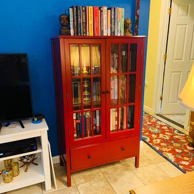 LOT 330: Red Wooden Book Case with Drawer and Glass Front Doors Books, and Book Ends