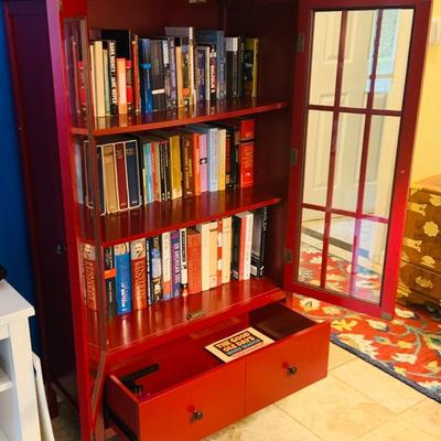 LOT 330: Red Wooden Book Case with Drawer and Glass Front Doors Books, and Book Ends