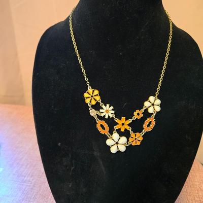 Sale Photo Thumbnail #44: Lot of 2 necklaces including
Cord necklace with flower pendant
Metal floral necklace in orange,white & gold