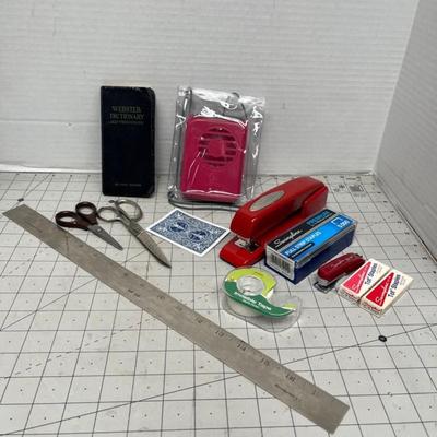 Sale Photo Thumbnail #1708: Assorted classic office items including staplers, scissors, ruler, tape, and mini dictionary.