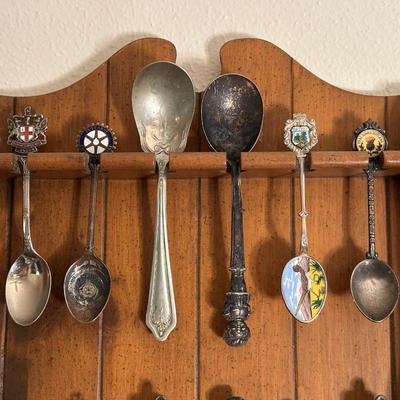 SOUVENIR SPOONS IN WOODEN RACKS