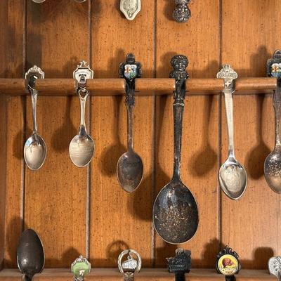 SOUVENIR SPOONS IN WOODEN RACKS