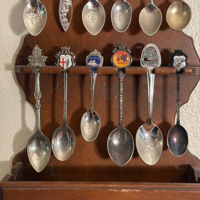 SOUVENIR SPOONS IN WOODEN RACKS