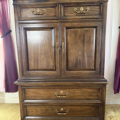 Sale Photo Thumbnail #39: This freestanding wardrobe is a vintage reproduction crafted from dark wood, featuring a classic brown finish. It includes two doors and two drawers, with brass-finished handles, and is designed for bedroom use. The wardrobe requires no assembly or additi