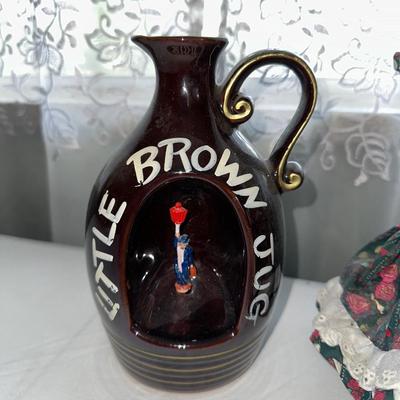 MUSICAL LITTLE BROWN JUG, DOLL AND METAL TIN