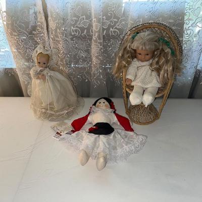 3 SMALLER DOLLS PLUS A WICKER DOLL CHAIR