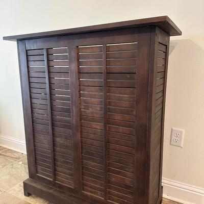 Sale Photo Thumbnail #7: Compact wooden bar cabinet with slatted sides and back, three open shelves, and a bottom rack with slots for storing up to 6 bottles. 

Dimensions: 43.5” tall x 39.5” wide x 16.5” deep