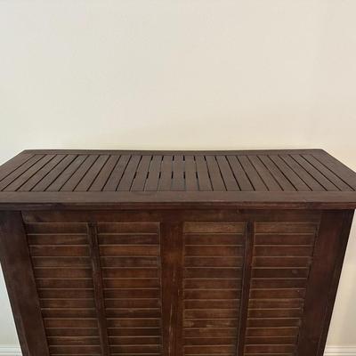Sale Photo Thumbnail #2: Compact wooden bar cabinet with slatted sides and back, three open shelves, and a bottom rack with slots for storing up to 6 bottles. 

Dimensions: 43.5” tall x 39.5” wide x 16.5” deep