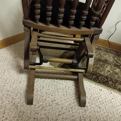 ANTIQUE GLIDER ON CASTERS WITH A VELVET COVERED SEAT