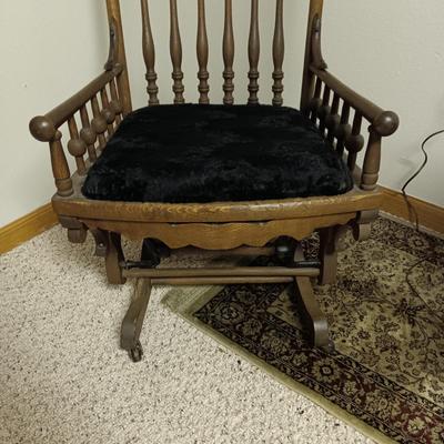 ANTIQUE GLIDER ON CASTERS WITH A VELVET COVERED SEAT