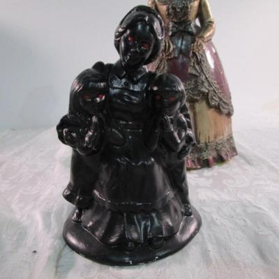 2 statuettes, 1 is mom with 2 kids, 1 Victorian woman