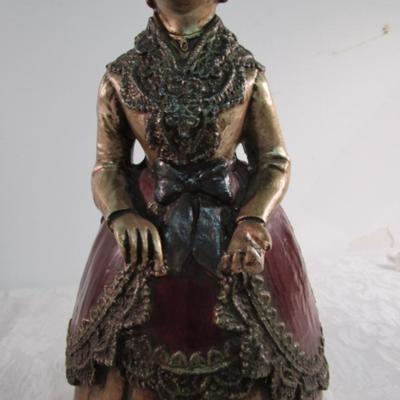 2 statuettes, 1 is mom with 2 kids, 1 Victorian woman