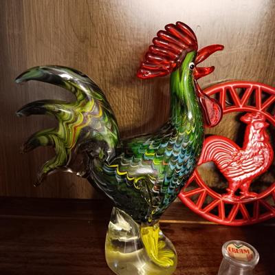 MULTI COLORED GLASS ROOSTER, CAST IRON TRIVET, CLAY EGG SEPARATOR & GLASS CREAM CONTAINER