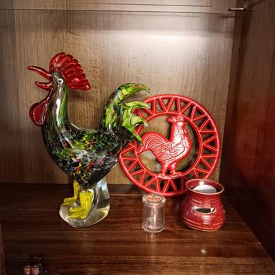 MULTI COLORED GLASS ROOSTER, CAST IRON TRIVET, CLAY EGG SEPARATOR & GLASS CREAM CONTAINER