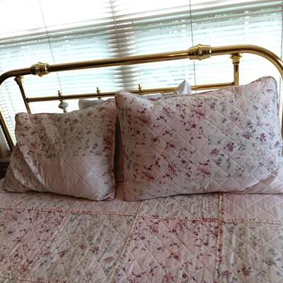 QUEEN SIZE BED W/DOWN FILLED MATTRESS TOPPER, ALL THE BEDDING, BRASS COLORED HEADBOARD AND FRAME ON CASTERS