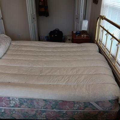 QUEEN SIZE BED W/DOWN FILLED MATTRESS TOPPER, ALL THE BEDDING, BRASS COLORED HEADBOARD AND FRAME ON CASTERS