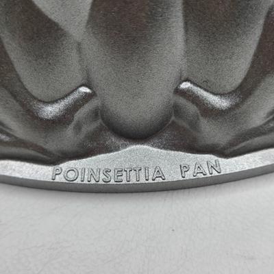 LOT 200: Cookbooks, Specialty Rolling Pins, Bundt Cake Pan, Handmade in Sweden Table Linen , Tile Trivet, Harkerware Serving Dish, and...