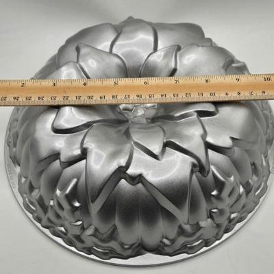 LOT 200: Cookbooks, Specialty Rolling Pins, Bundt Cake Pan, Handmade in Sweden Table Linen , Tile Trivet, Harkerware Serving Dish, and...