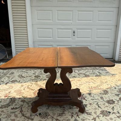 Folding table with music scroll motif base