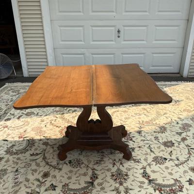 Folding table with music scroll motif base