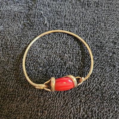 Sale Photo Thumbnail #352: This auction lot is for a Designer Handmade Bracelet with Inset Orangey Stone.  The wire has a gold tone finish.  Nice for showy wear.