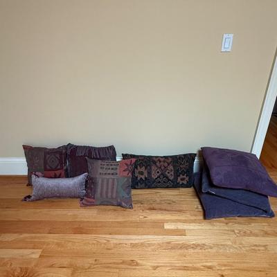 Lot of throw pillows, mostly purple