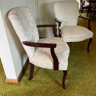 Sale Photo Thumbnail #4: Upholstered armchairs featuring cream fabric with a subtle damask pattern. Chairs have carved wood frames with curved arms and cabriole legs, showcasing classic design elements. Frames are in a polished wood finish. Overall condition appears to be good.