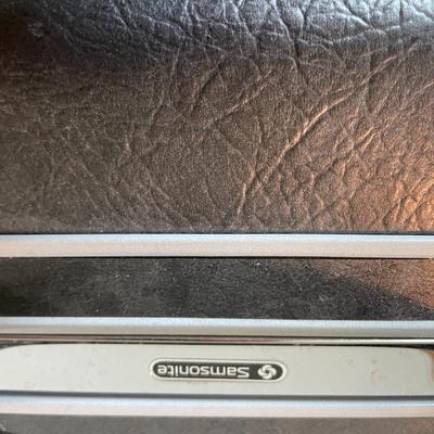 Sale Photo Thumbnail #25: Three hard-shell suitcases including a Samsonite piece and two unbranded suitcases. The Samsonite case features black textured exterior and branding on the latch hardware. The second case is green with a light interior, and the third is a darker, smaller 