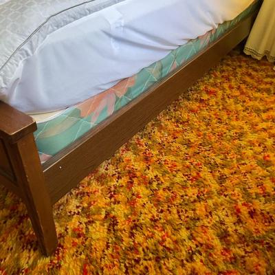 Sale Photo Thumbnail #215: Full-size wooden bed frame featuring a solid headboard with rectangular cutouts on either side and a matching paneled footboard. The bed is constructed from wood with a warm brown finish and includes slatted wooden supports. The frame measures approximate