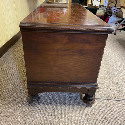 Sale Photo Thumbnail #364: Lane cedar hope chest featuring an ornate wood-carved design. The chest is constructed with cedar-lined interiors for preservation of stored items and has the Lane logo, along with details about patents, stamped on the inside of the lid. The chest has a p