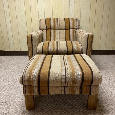Sale Photo Thumbnail #408: Mid-century upholstered armchair and matching ottoman featuring a striped fabric design in neutral tones. The chair includes a decorative wood back panel and sturdy legs. The ottoman complements the chair with the same fabric and wooden legs. Dimensions: 