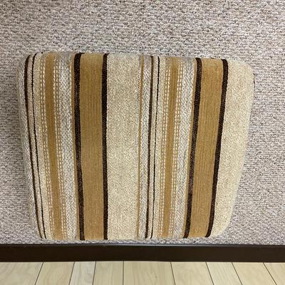 Sale Photo Thumbnail #418: Mid-century upholstered armchair and matching ottoman featuring a striped fabric design in neutral tones. The chair includes a decorative wood back panel and sturdy legs. The ottoman complements the chair with the same fabric and wooden legs. Dimensions: 