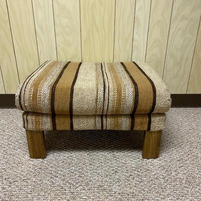 Sale Photo Thumbnail #414: Mid-century upholstered armchair and matching ottoman featuring a striped fabric design in neutral tones. The chair includes a decorative wood back panel and sturdy legs. The ottoman complements the chair with the same fabric and wooden legs. Dimensions: 