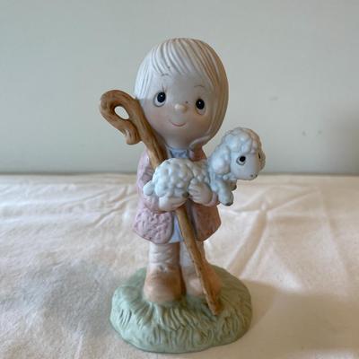 Sale Photo Thumbnail #510: Precious Moments porcelain bisque figurine titled 'We Have Seen His Star,' item number 5746. The figurine features a young shepherd holding a staff and carrying a lamb. Measures approximately 5 inches in height. Marked on the underside with the Precious M