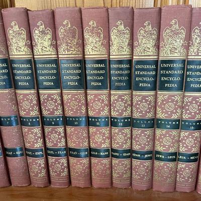 Sale Photo Thumbnail #577: Complete set of Universal Standard Encyclopedia volumes, bound in uniform red covers with embossed design and decorative gilded spines. Includes multiple volumes arranged alphabetically by subject. The binding is cloth-covered hardback, combining durabili