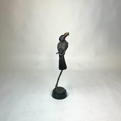 Sale Photo Thumbnail #95: Made out of bronze and polychrome.Hornbill depicted with an egg in its beak, its talons gripping a curved branch; on black round stepped plinth base.  
Measurements:
Bird is 14.5" height, 6.5" diameter for base, total height is 28" height
Valued @ $2500.0